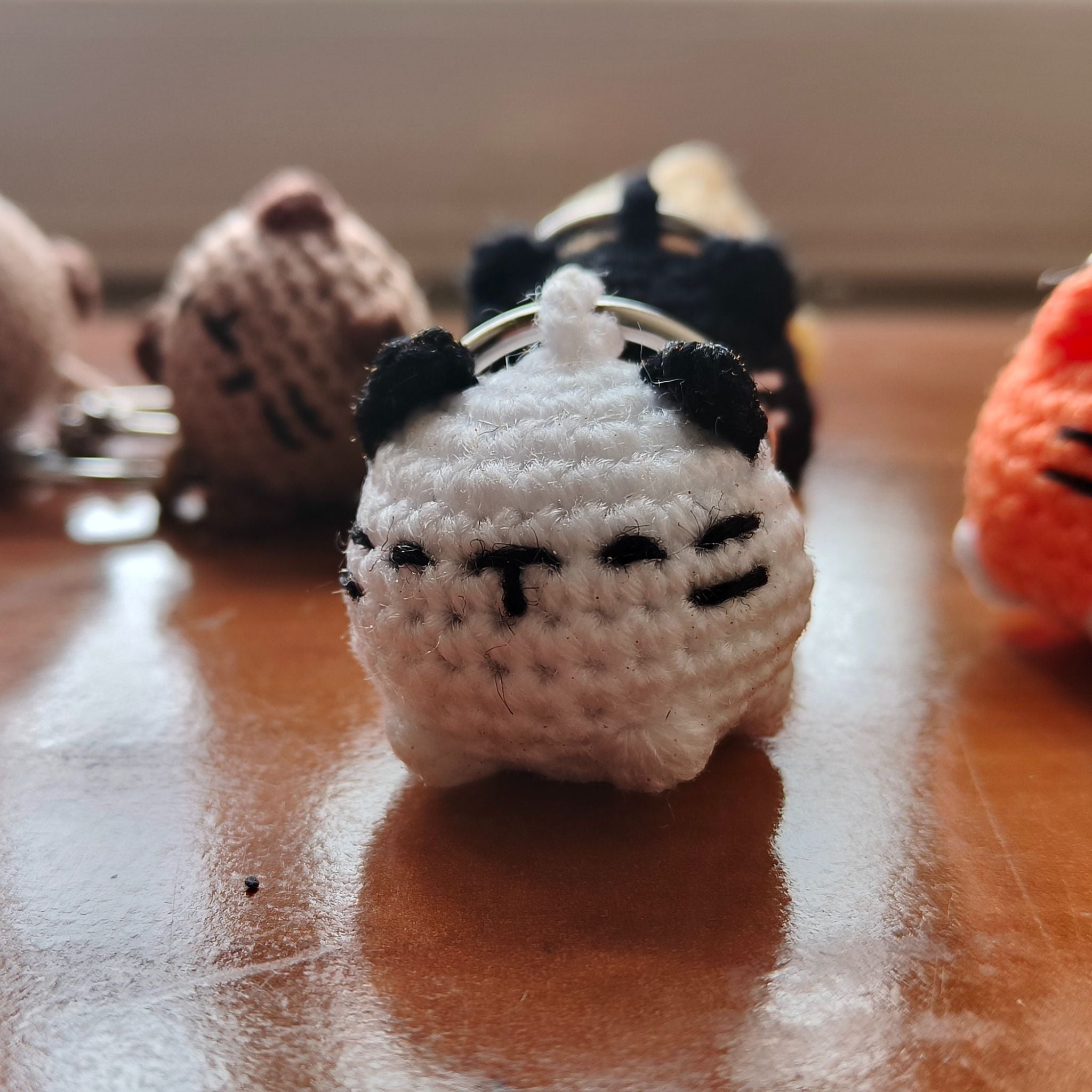 Small white and black knitted cat toy on a wooden surface